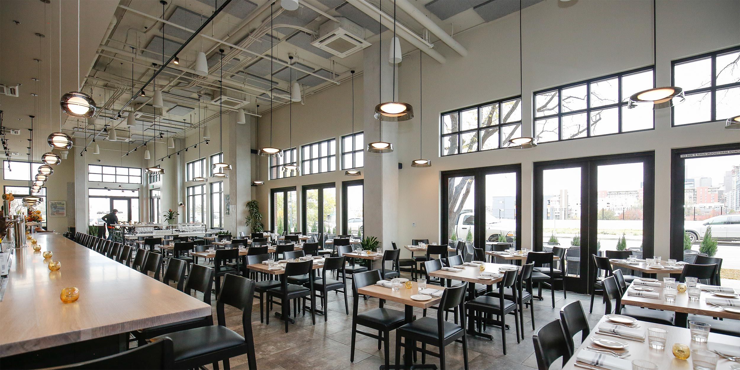 A contemporary restaurant interior with neatly arranged tables and chairs.